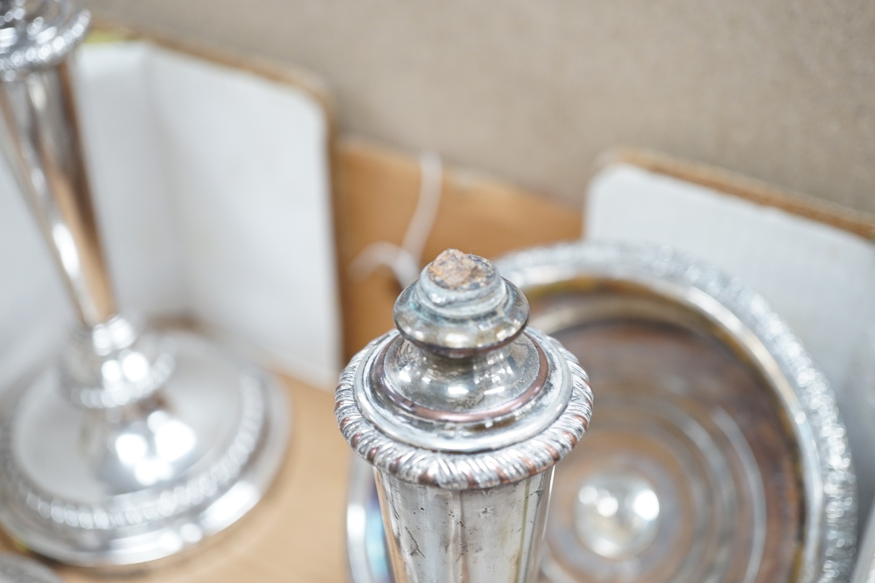 Plated wares: a pair of wine coasters, two ornate basket-edged dishes, a sugar bowl, three candlesticks, three candleholders, a teapot, ice bucket cased serving spoons and a metal mounted glass decanter.